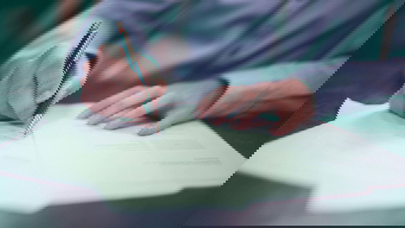 altersgrenze-beamte.jpg Ein Mann unterzeichnet Unterlagen