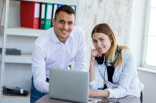 arbeitsfeld-oeffentlicher-dienst.jpg Arbeiten im öffentlichen Dienst: Eine Frau und ein Mann in einem Büro am Laptop vor einem Regal mit Aktenordnern