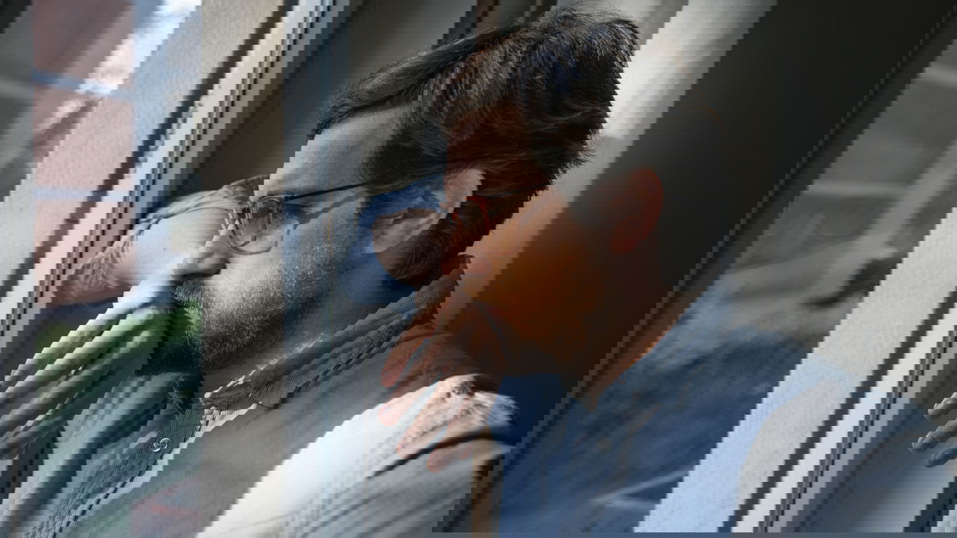 arbeitslose-akademiker.jpg Ein arbeitsloser Akademiker blickt nachdenklich aus dem Fenster