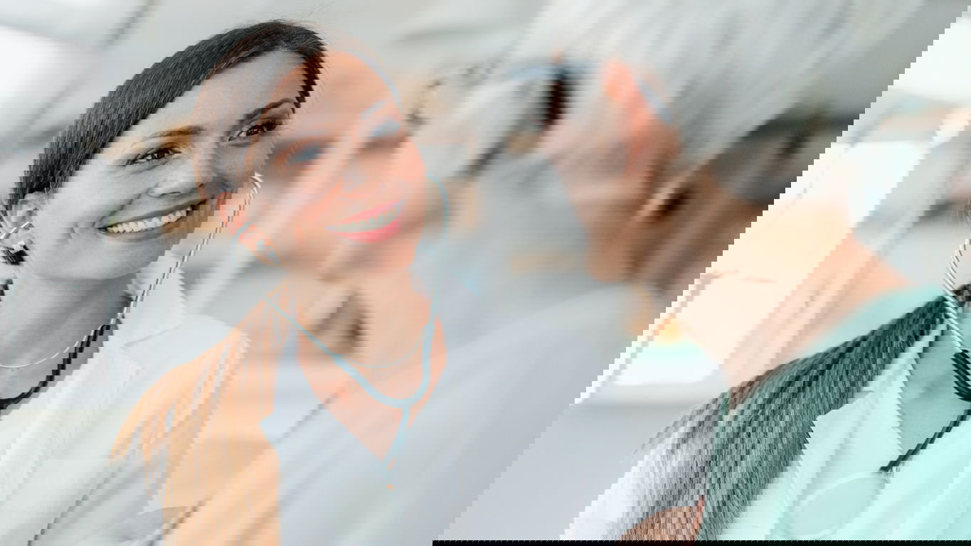 assistenzarzt-gehalt1.jpg Eine lächelnde Assistenzärztin im Gespräch mit einer Patientin
