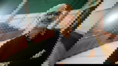 aufgaben-professor.jpg Ein lächelnder, älterer Professor in einem Hörsaal