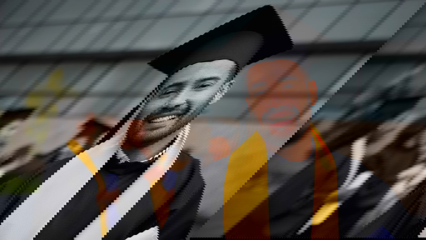Ausländisches Diplom_foto Hispanolostic_iStock-1349302576.jpg Dunkelhäutiger Mann mit Doktorhut und Abschlusszeugnis