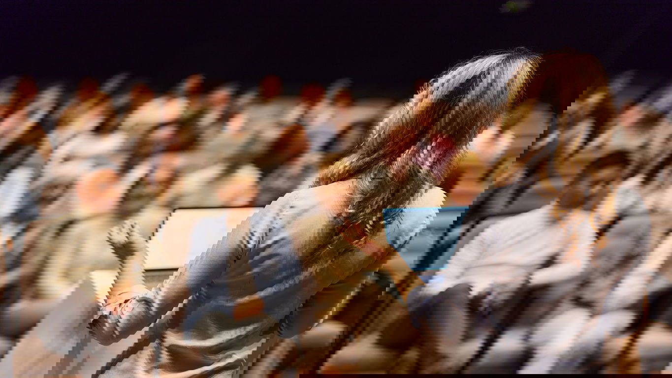 berufungsvortrag.jpg Eine Frau mit langen blonden Haaren hält einen Berufungsvortrag