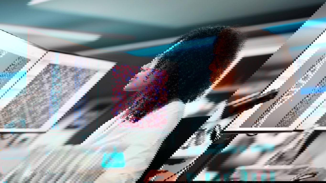 bioinformatik-gehalt.jpg Eine Bioinformatikerin betracht am Monitor eine DNA-Darstellung