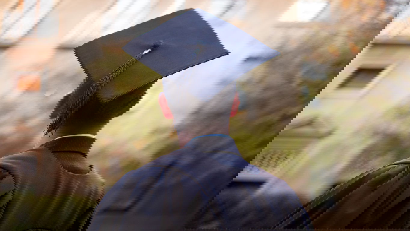 doktortitel-fuehren.jpg Ein junger Mann mit Doktorhut von hinten fotografiert