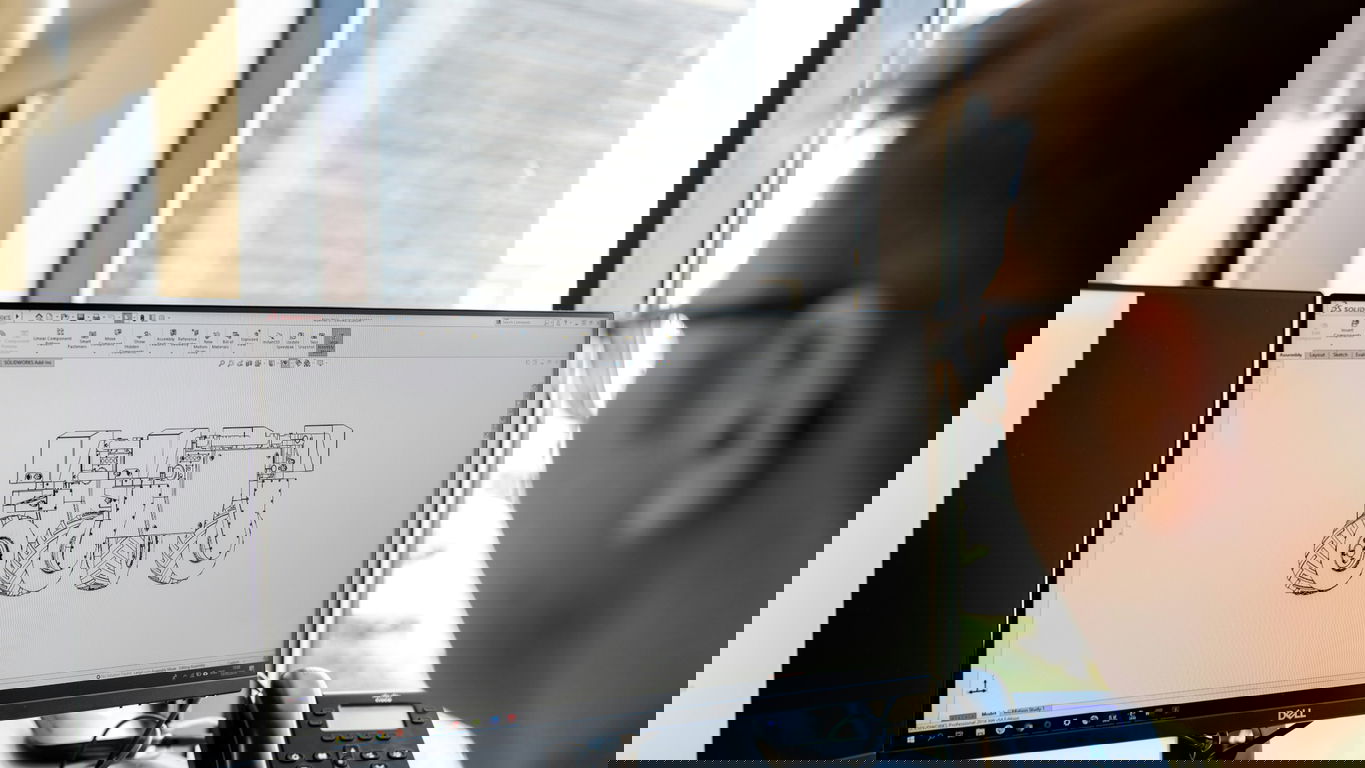 entwicklungsingenieur.jpg Ein Entwicklungsingenieur betrachtet eine Zeichung auf dem Monitor am Schreibtisch