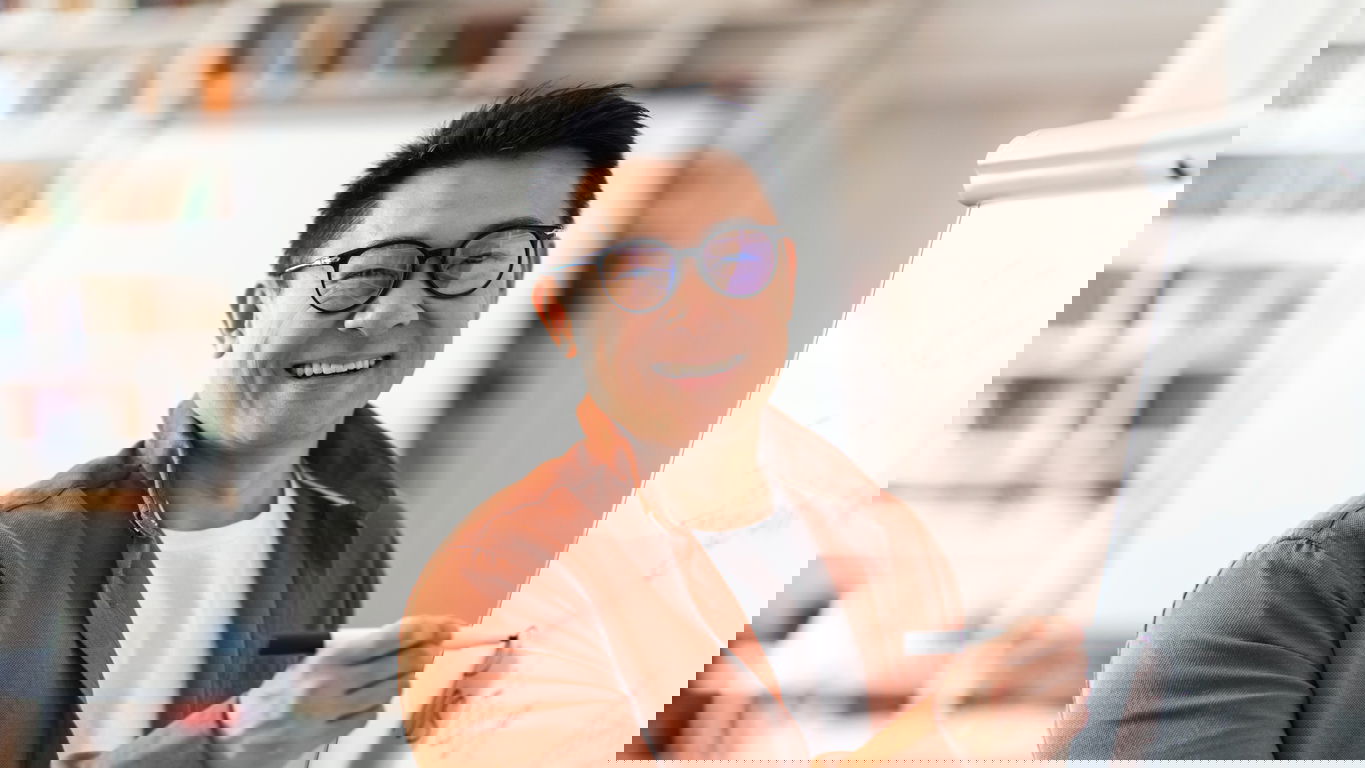 gehalt-dozent.jpg Ein asiatischer, lächelnder Dozent an einem Whiteboard