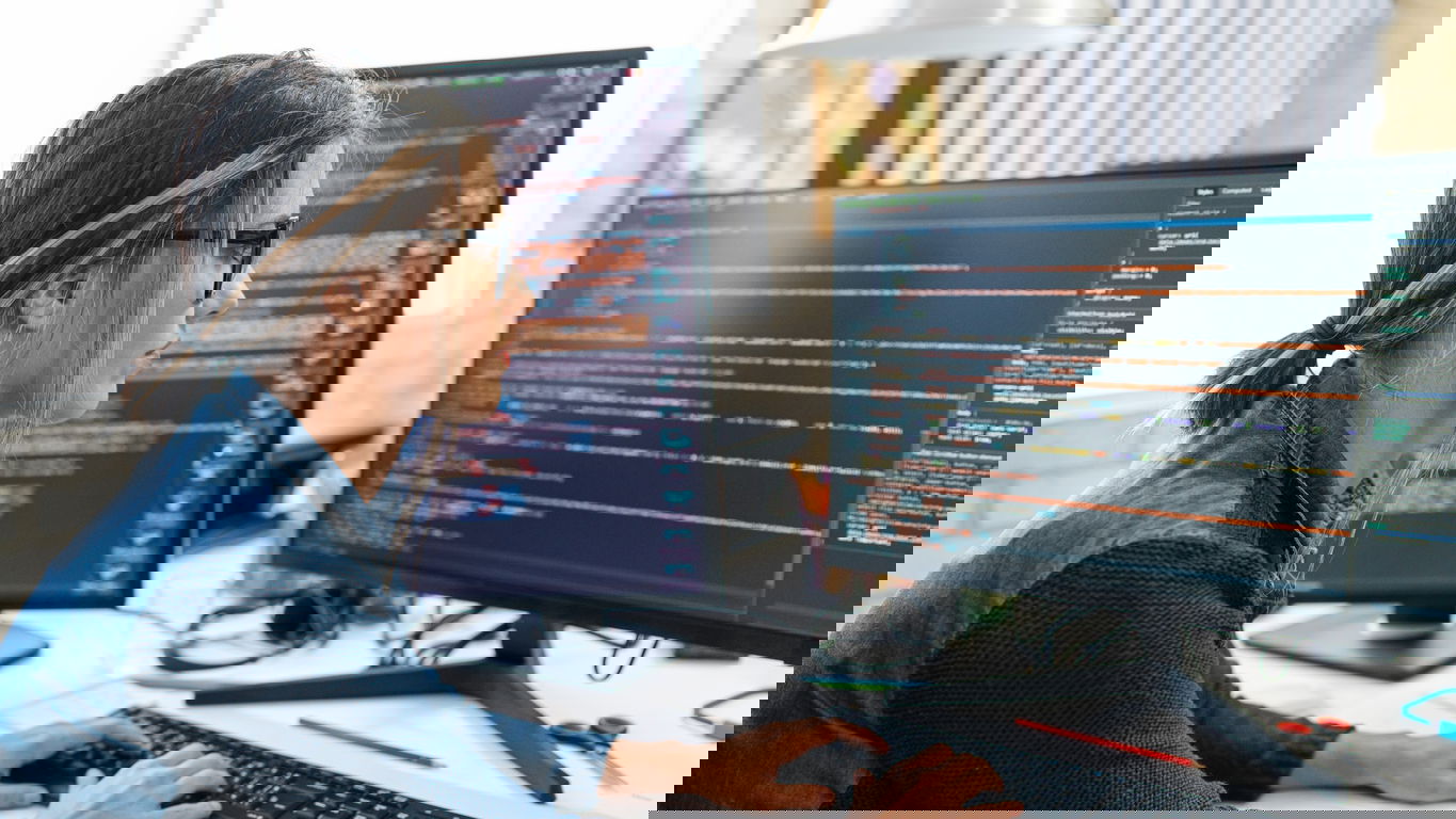 informatik-it-gehalt.jpg Eine Softwarentwicklerin vor zwei Bildschirmen; wie hoch ist ihr Gehalt?