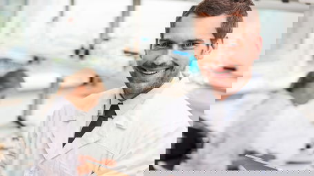 Laborleiter.jpg Ein lachender Laborleiter mit Klemmbrett