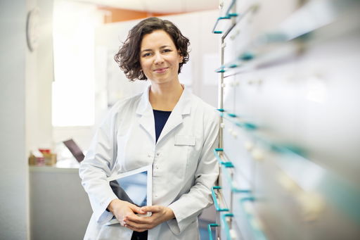 postdoc-switzerland.jpg Eine Postdoktorandin lehnt lächelnd an einem Regal mit Schubfächern