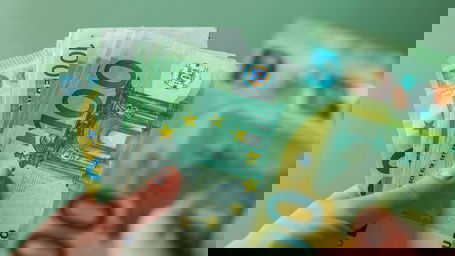 professor-gehalt-bundesland.jpg Eine Frau hält eine Hand voll Hunderteuroscheine