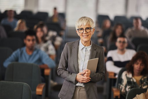 professur.jpg Eine ältere Professorin in einem Hörsaal