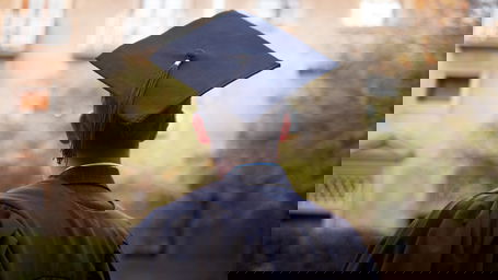 promotion-ausland.jpg Ein junger Mann von hinten mit Doktorhut