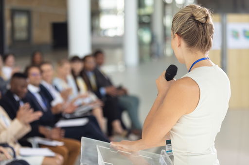 publizieren-praesentieren.jpg Eine junge Frau hält einen wissenschaftlichen Vortrag vor Publikum