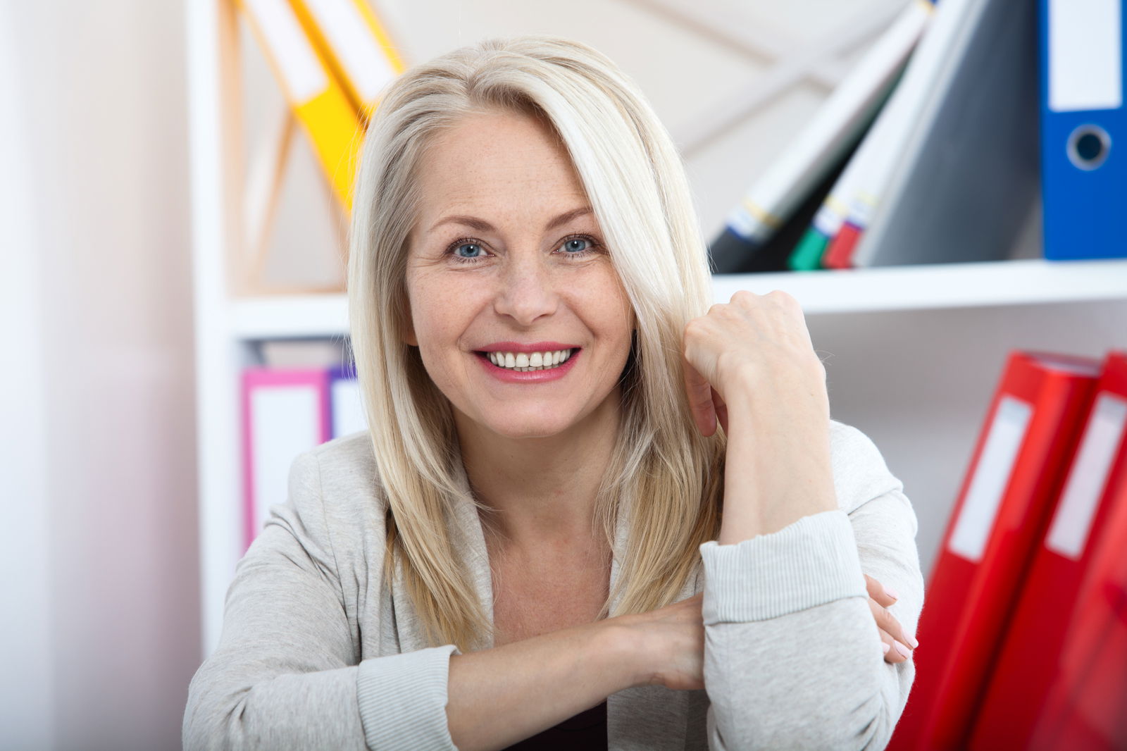 Auf Lebenszeit verbeamtet: Eine glückliche Beamtin in ihrem Büro
