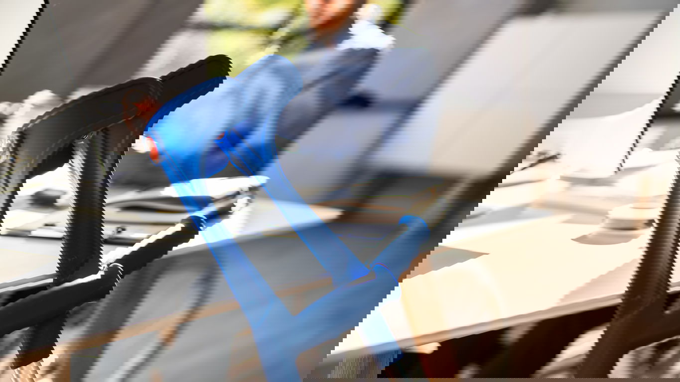 wiedereingliederung.jpg Ein Mann im Rollstuhl an einem Schreibtisch, an dem zwei Krücken lehnen