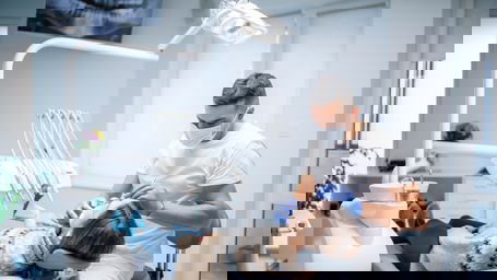 zahnarzt-gehalt.jpg Ein Zahnarzt behandelt eine Patientin